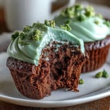 Festive green velvet cupcakes with cocoa flavor, topped with smooth cream cheese frosting for St. Patricks Day celebrations.