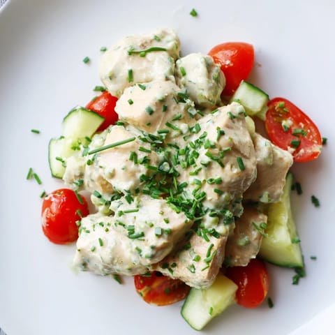 Creamy avocado ranch chicken salad with tender grilled chunks, cherry tomatoes, cucumbers, and fresh herbs served over crisp greens.  