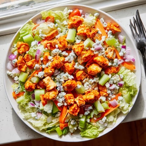 Hearty Buffalo Chicken Chopped Salad featuring diced celery, red onion, and a drizzle of ranch dressing.  