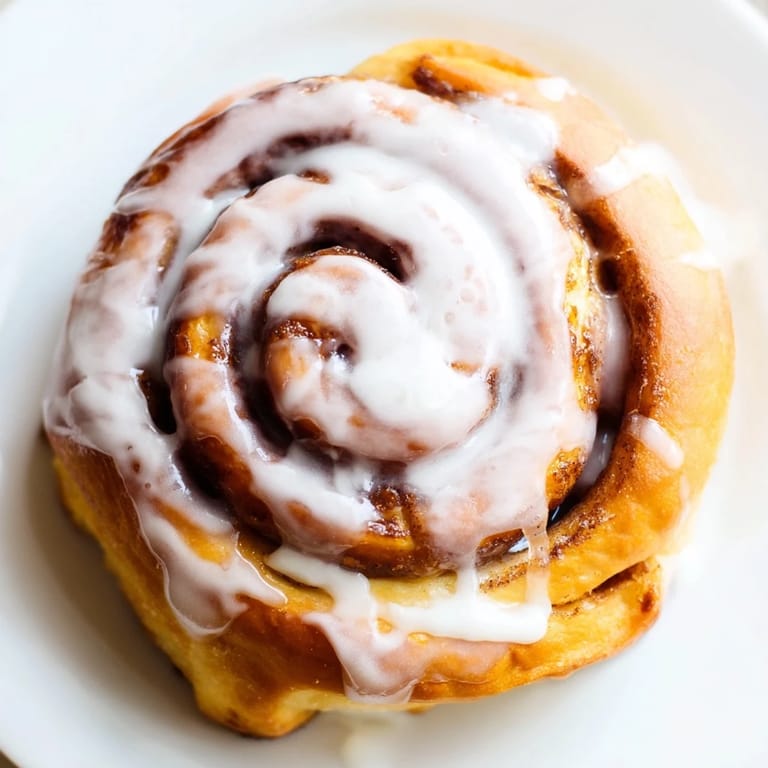 Warm homemade Cinnamon Rolls with fluffy spirals, rich brown sugar filling, and sweet glaze dripping down the sides.