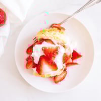 Homemade Strawberry Shortcake biscuits, golden brown and split open, layered with juicy macerated strawberries and fluffy whipped cream.