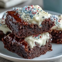 Rich, fudgy brownie bites with creamy frosting and red, white, and blue sprinkles for a festive 4th of July dessert.